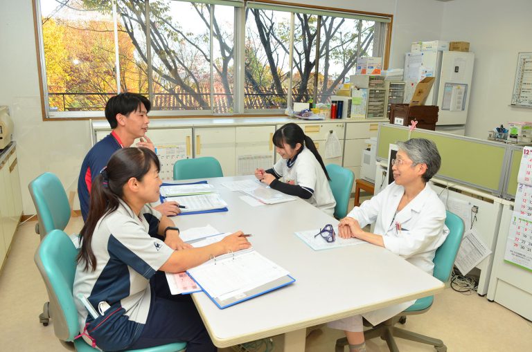 医療職員による入居者との相談・診察風景。窓からの採光が良い医務室。